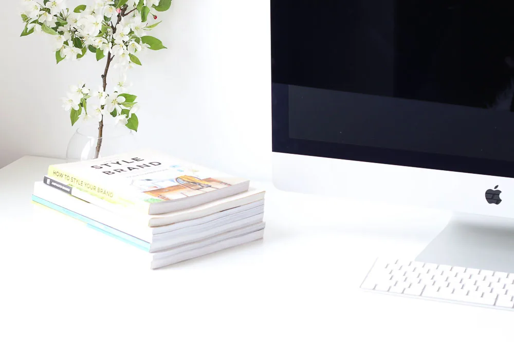 iMac mit Büchern auf einem hellen Schreibtisch